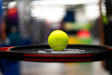Tennis ball on top of a tennis racket.
