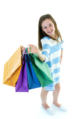 Teenager girl shopping in a store with large paper bags.