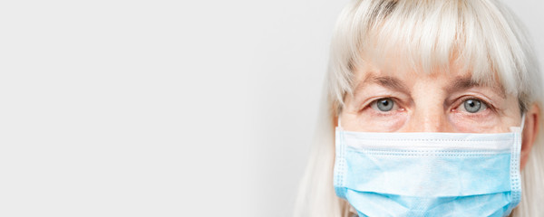 Adult woman in a medical mask looks at the camera. Virus protection. Stop virus infection.