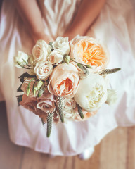 Bridesmaid holding a peach and pink bouquet of flowers
