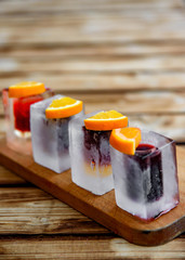 set of shots alcohol drinks in glasses on wooden plate