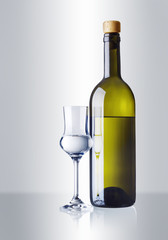 ein Glas und eine Flasche mit Grappa