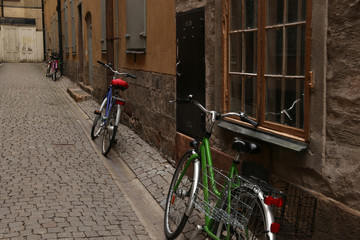 Fototapeta na wymiar Parked bikes along house facade in old town of Stockholm, Sweden