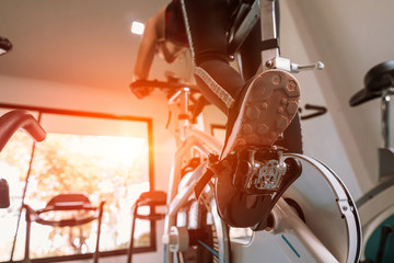 Fit woman working out on exercise bike at the gym. Healthy and funny lifestyle concept.
