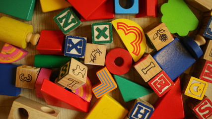 Wooden alphabet blocks isolated on wooden background close up