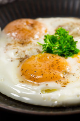 Fried eggs and bread for breakfast on a gray background.