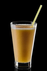 Glass of orange and banana smoothie isolated on black background