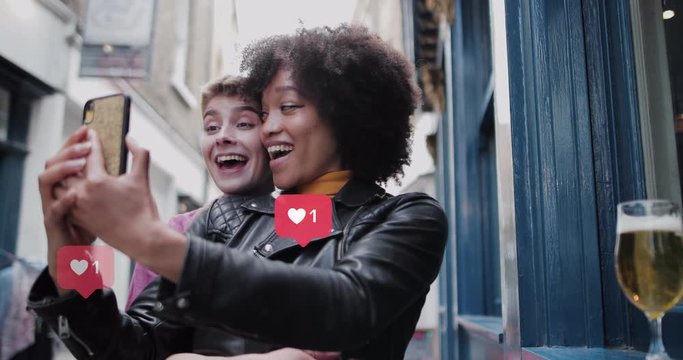 Friends using smart phone for selfie with animation of likes button on social media
