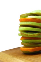 Fototapeta na wymiar Slices of apple, kiwi and orange stacked in a tower