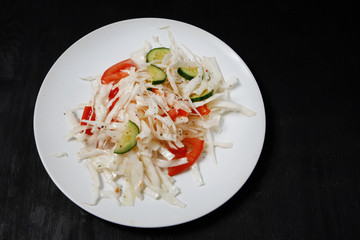 Plate with salad on the table.