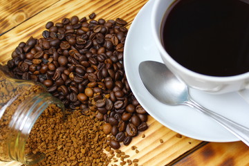 Instant coffee next to grains and a cup of hot drink