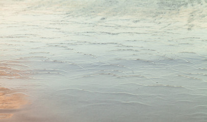 Wet shiny coastal sand, abstract natural background