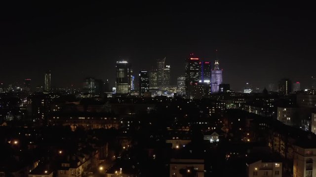 Warsaw Poland. 07. January. 2020.  Aerial view of skyscrapers at dusk and city traffic in the center of Warsaw. Drone flies towards the glass skyscrapers at night. 4K Shot.