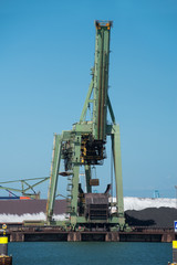 Fototapeta na wymiar Netherlands, Rotterdam - July 30, 2019; Coal terminal wih big industrial cranes for handling coal transportation on the Maasvlakte in the port of Rotterdam