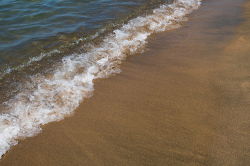 Waves and black sand of volcanic origin. Baia Domizia Coast, Province of Caserta, Italy