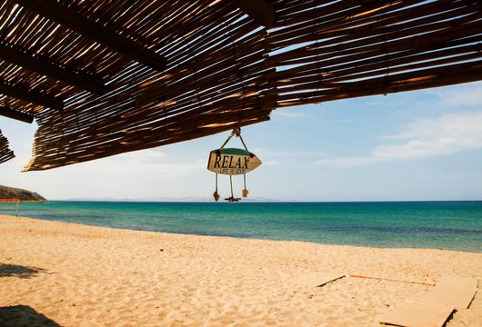 Empty beach, sunshade with text"life is good", Limnos.
