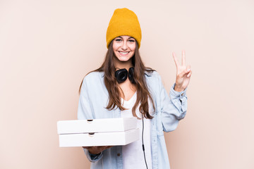 Young caucasian woman holding pizzas isolated showing number two with fingers.