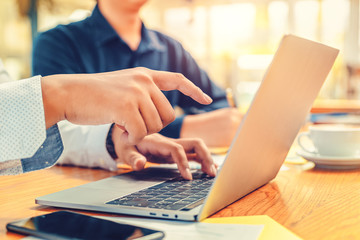 hand pointing to a laptop between businessman meeting and working together at office.