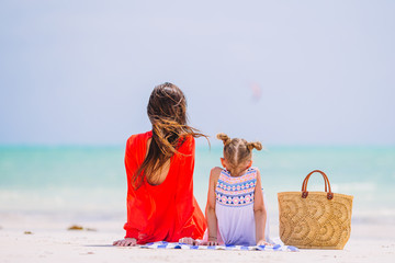Beautiful mother and daughter at the beach enjoying summer vacation.
