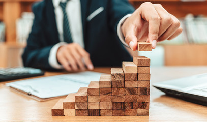Ant eye view Male hand stacking wooden blocks. Business development and growth concept