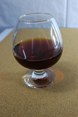 a glass of red wine on the table on a wooden background