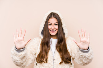 Young caucasian woman posing isolated showing number ten with hands.