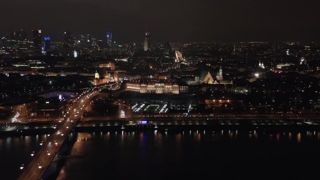 Aerial view of the old city and the river hung with a bridge at night. Drone shot the city landscape with a river and a royal palace, the facade of which.
