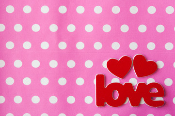 word Love with red hearts on pink polka dot background. Greeting card