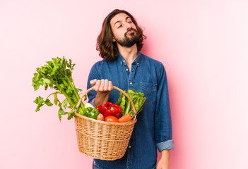 Young man picking organic vegetables from his garden isolated dreaming of achieving goals and purposes