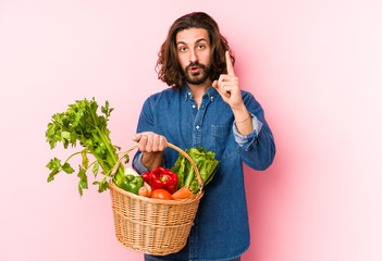Young man picking organic vegetables from his garden isolated having an idea, inspiration concept.