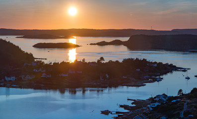 Setting sun over Archipelago of Rörtången and big island Brattön Sweden - Low sun casts light over reflecting sea and valley.