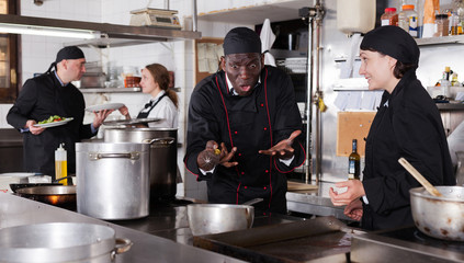 Chef male dissatisfied with the work of girl helper