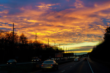 Traffic on road at beautiful sunrise sky with clouds
