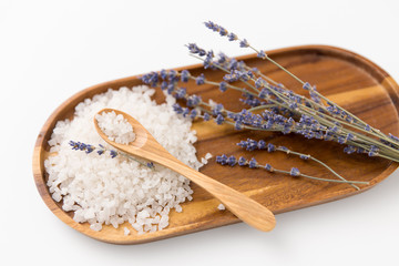 beauty and wellness concept - sea salt heap, lavender and spoon on wooden tray