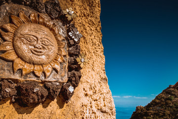 Symbol słońca wyryty na murku na Sycylii