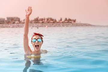 Desperate asian woman swimming in the sea and asking for help, shouts and raises her hand. Concept of accidents and drowning in water, lifeguard on the beach