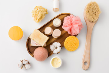 beauty, spa and wellness concept - close up of konjac sponge, crafted soap bars on wooden tray and...