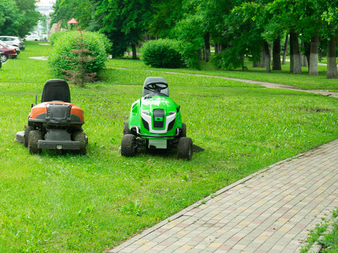 Professional lawn mower cuts the grass. Mowing in parks and residential areas.