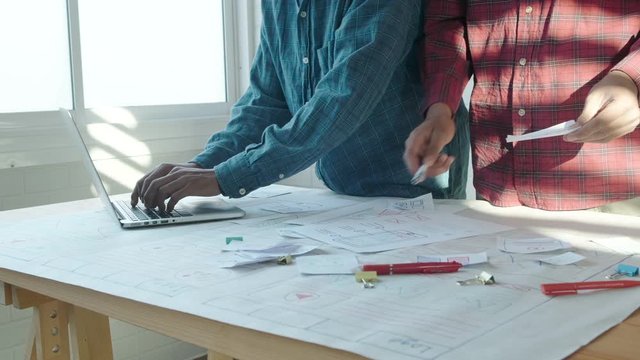 Web designer working laptop responsive design. Creative UI Ux designer teamwork meeting planning designing wireframe layout application development for smartphone screen mobile phone technology
