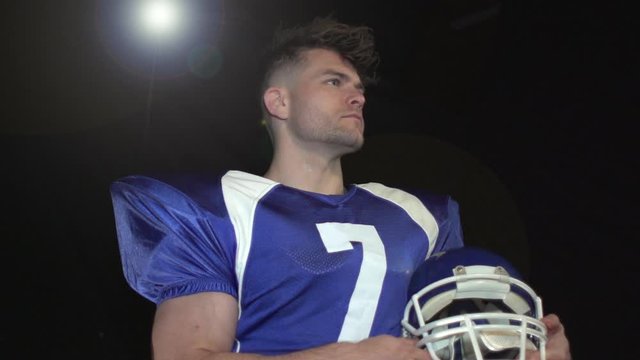 American Football Quarterback Portrait. Black Background. Super slow motion. Rotating around
