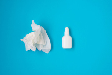 Treatment of colds and flu. Various medicines, a thermometer, sprays from a stuffy nose and a pain in a throat on a blue background. Copy space. Medicine flat lay.