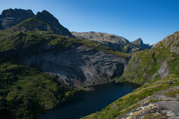 Tridalsvatnet Lake Landscape wedged between dramatic Steep Mountains in Sorvagen Lofoten Islands, Northern Norway. Beautiful View from Hiking trail.