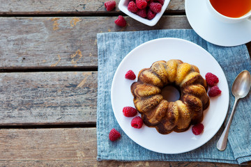 Chocolate marble bundt cake with a cup of tea on wooden table. Top view. Copy space.