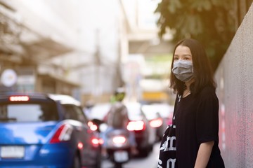 Asian travelers girl with medical face mask to protection the coronavirus on the street in Bangkok city