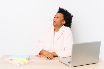 Middle aged african american woman working at home isolated relaxed and happy laughing, neck stretched showing teeth.