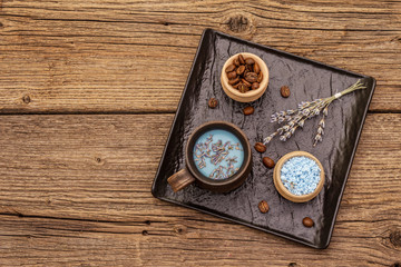 Trendy colored latte. Lavender and powdered aromatic sugar, coffee beans. Wooden boards background