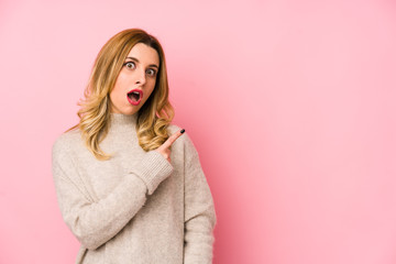 Young blonde cute woman wearing a sweater isolated pointing to the side