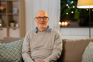 old age and people concept - happy smiling senior man in glasses at home in evening