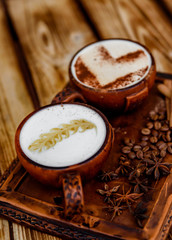 Two cups of cappuccino coffee with latte art on woden table background