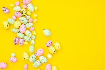 Quail Easter eggs frame isolated on yellow background. Copy space, top view